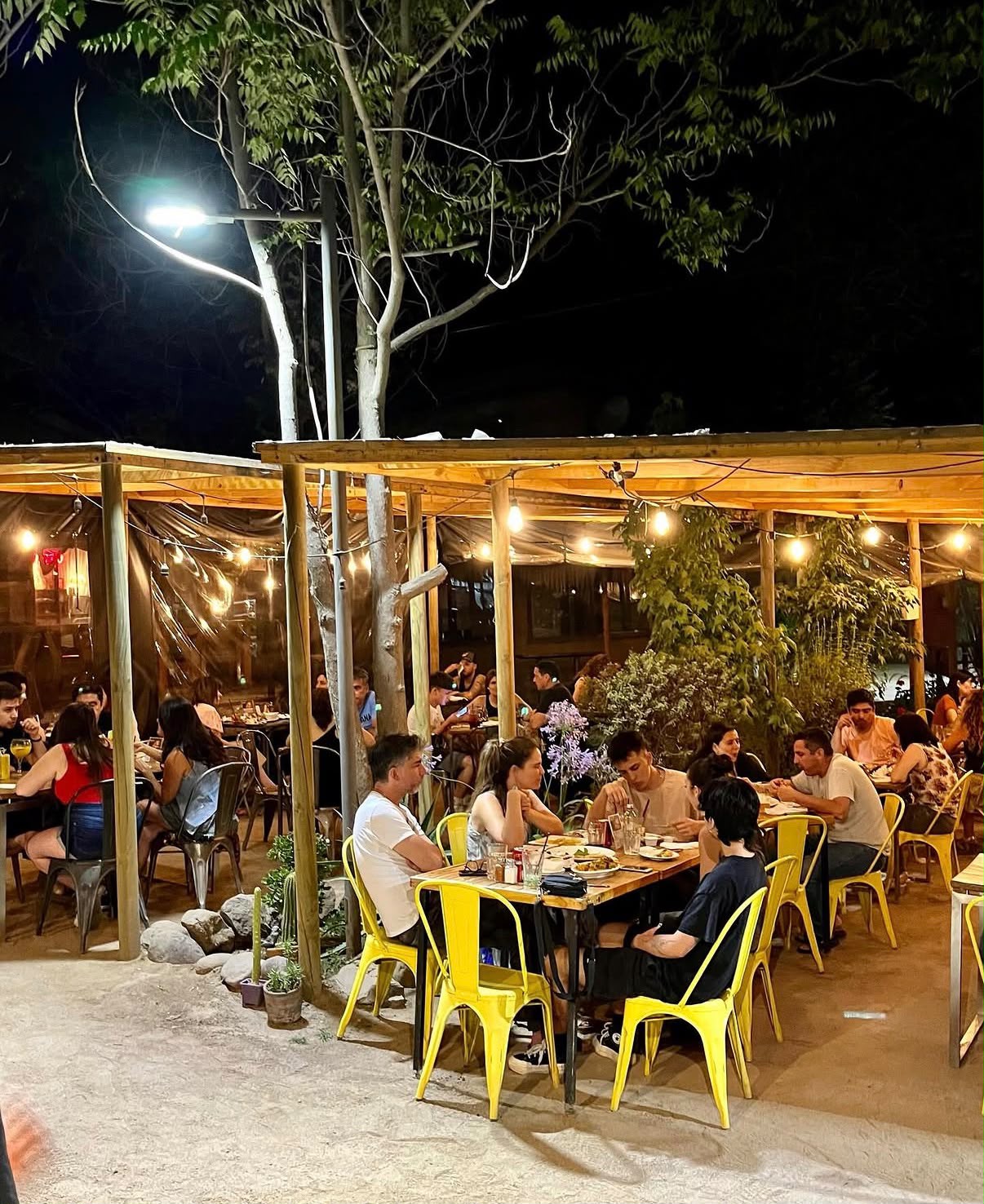 Terraza de Bravo's Restobar de noche, con luces cálidas y mesas ocupadas