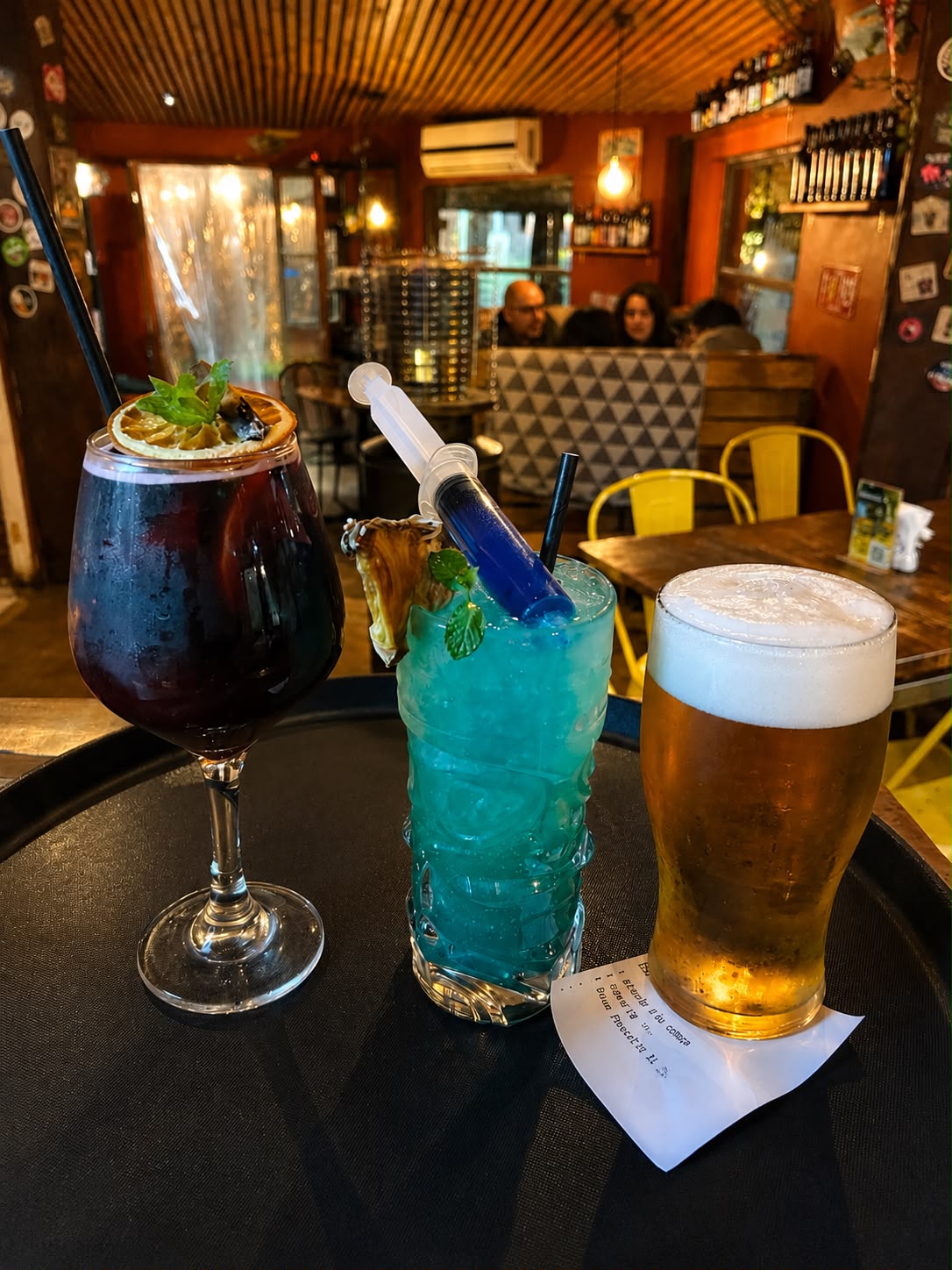 Tragos servidos en el interior de Bravo's Restobar, con clientes de fondo